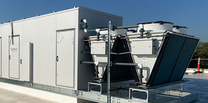 Large commercial HVAC system on top of building with bright blue sky in background